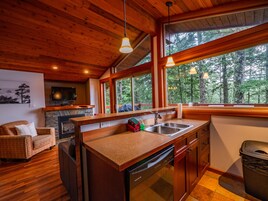 Un interior de madera con cocina, comedor y chimenea.