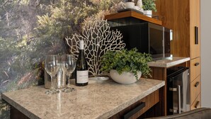 A kitchen counter with a wine bottle, glasses, and a plant. - Seaside Oceanfront Inn (Seaside)