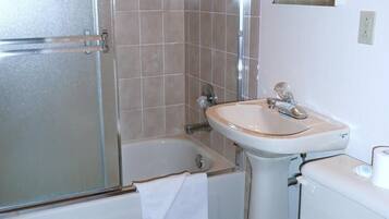 A bathroom with a bathtub, a sink, and a toilet.