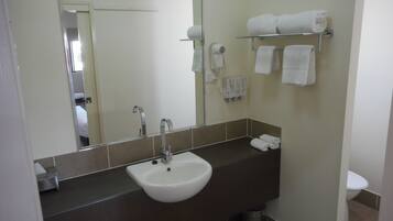 A bathroom with a sink, mirror, towel rack, and toilet.