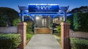L’entrée d’un restaurant, avec une enseigne indiquant « Seasons Restaurant & Wine Bar » et un poste de sécurité.