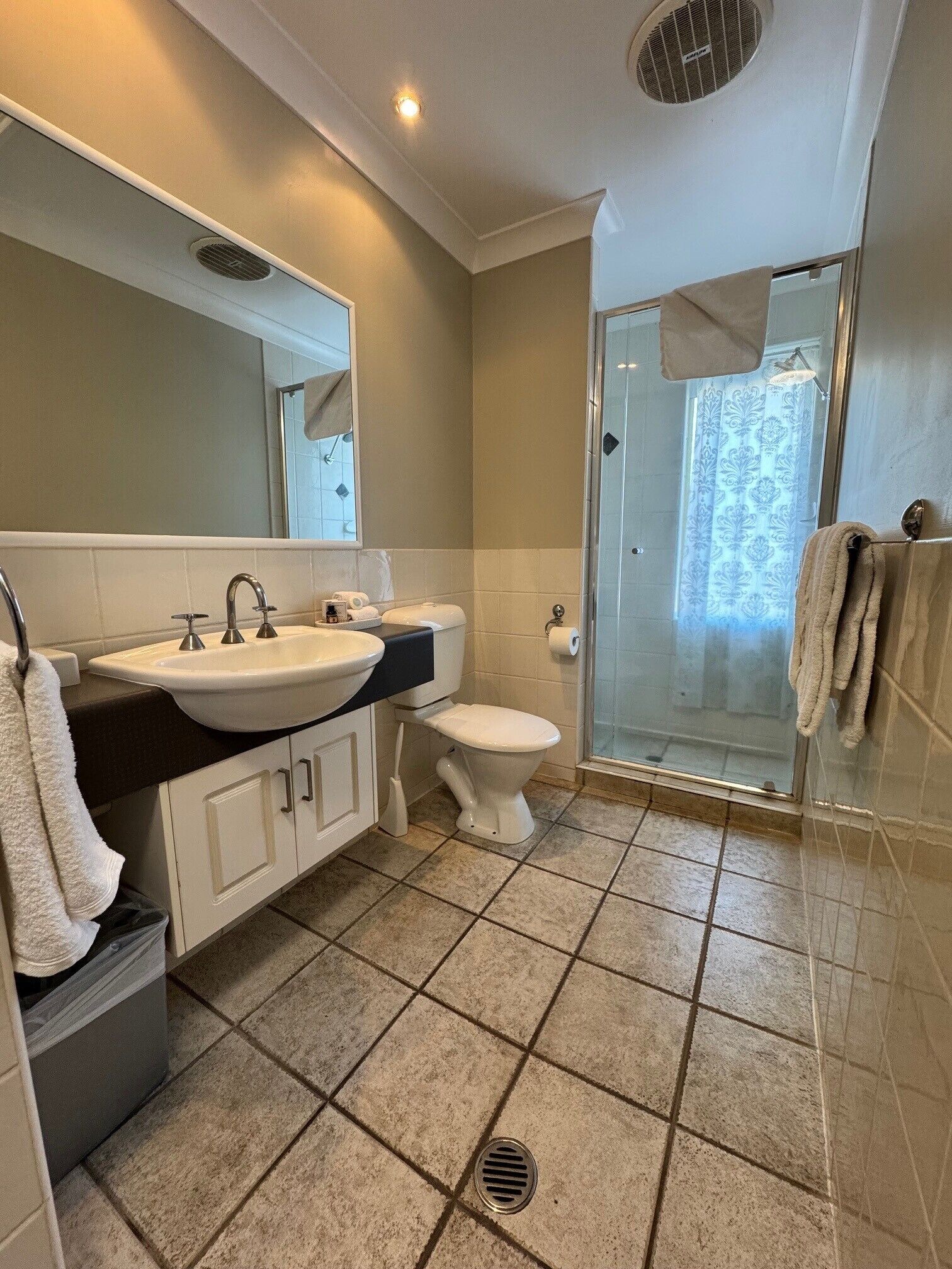 A bathroom with a sink, toilet, and shower area.
