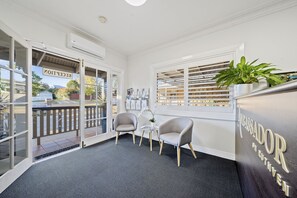 A reception area with a desk, two chairs, a potted plant, and a sign reading "RECEPTION."