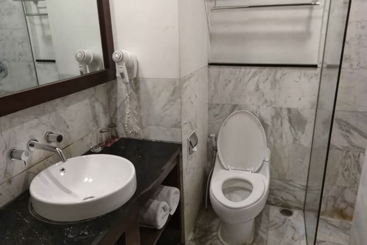 Un baño con lavamanos, inodoro y espejo de mármol.