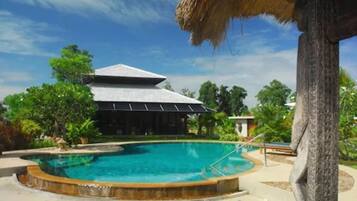 Alberca al aire libre y camastros