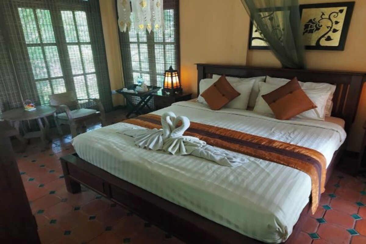 Una habitación de hotel con una cama, una mesita y una silla.