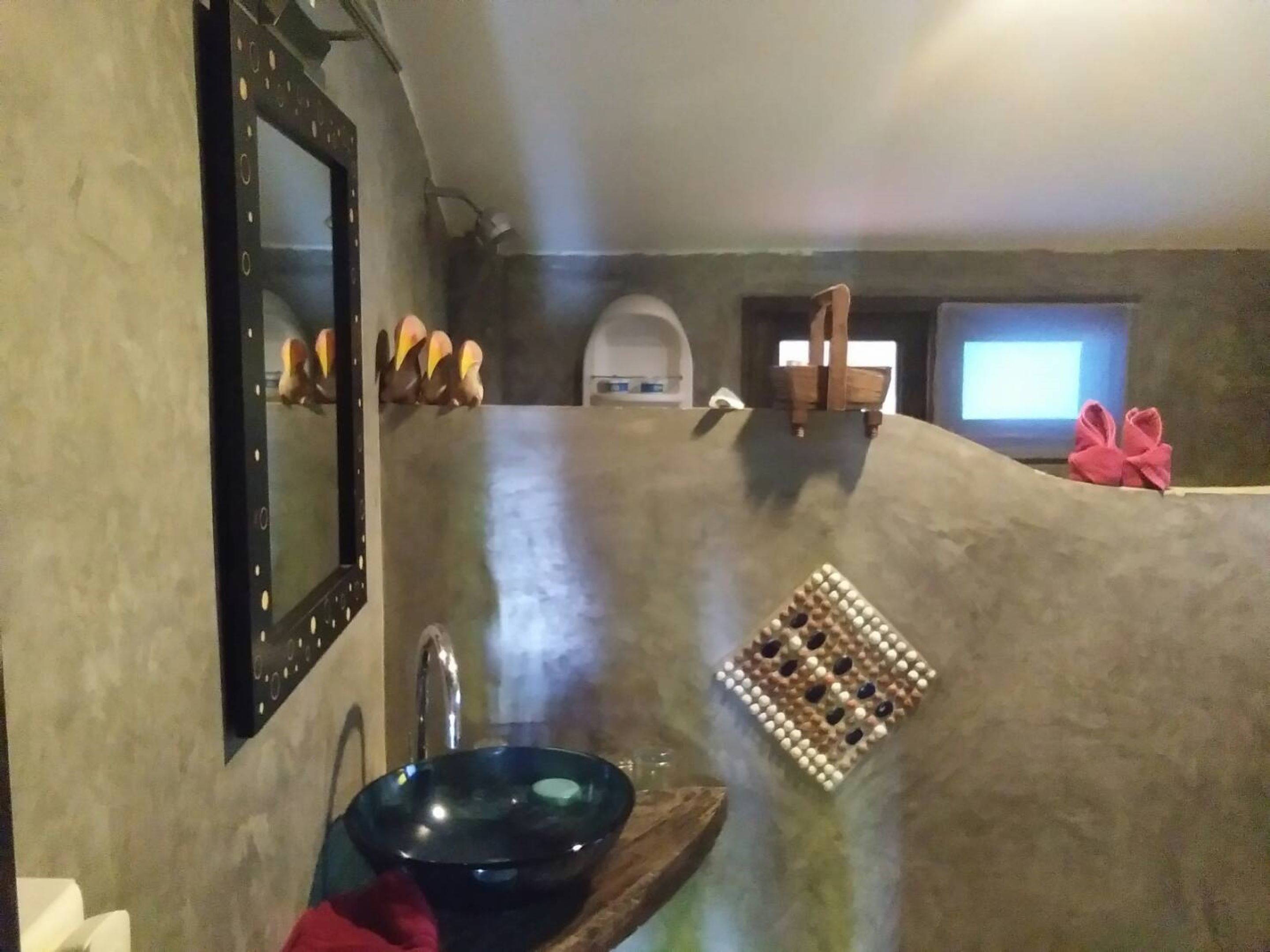 A bathroom with a large mirror, a sink, and a shower area.