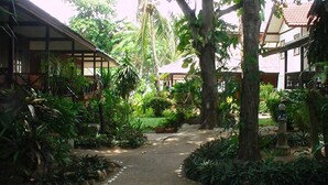 A courtyard with a pathway leading to a building with a sign that reads "HOTEL". - Utopia Resort (Koh Samui)