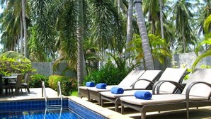 A poolside area with lounge chairs and a pool. - Baan Chaba Samui (Koh Samui)