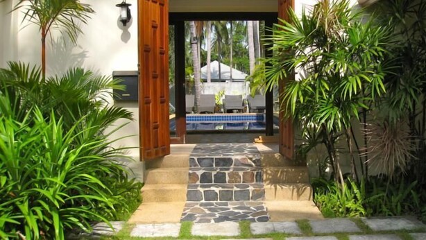 A pathway leading to a pool area with stone steps and tropical plants. - Baan Chaba Samui (Koh Samui)