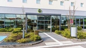 Ein Bed & Breakfast Hotel mit moderner Fassade, großem Glas Eingang und einem gepflegten Garten.