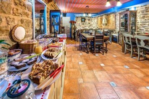 A buffet with various food items and a stone wall. - Archontiko Dilofou (Zagori)