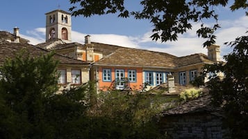A traditional building with a bell tower, stone walls, and a mix of colorful facades.