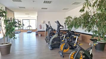 A gym with stationary bikes, treadmills, and exercise mats.