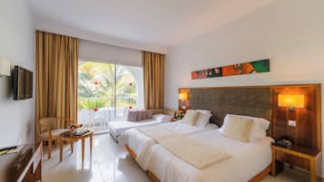 Ein Hotelzimmer mit einem großen Bett, einem Schreibtisch, einem Stuhl und Blick ins Freie.