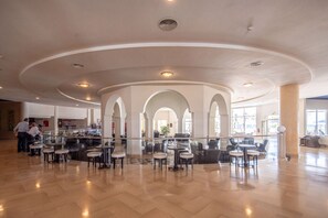 Ein großzügiger Innenbereich mit gewölbter Decke, verschiedenen Sitzgelegenheiten und einer zentralen Bar.