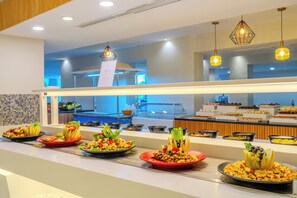 Un buffet proposant une variété de plats et un panneau indiquant le menu.