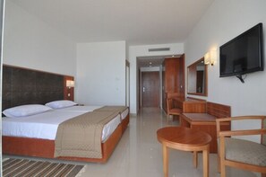 A hotel room with a bed, a TV mounted on the wall, a wooden desk, and a chair. - Khayam Garden Beach Resort & Spa (Nabeul)