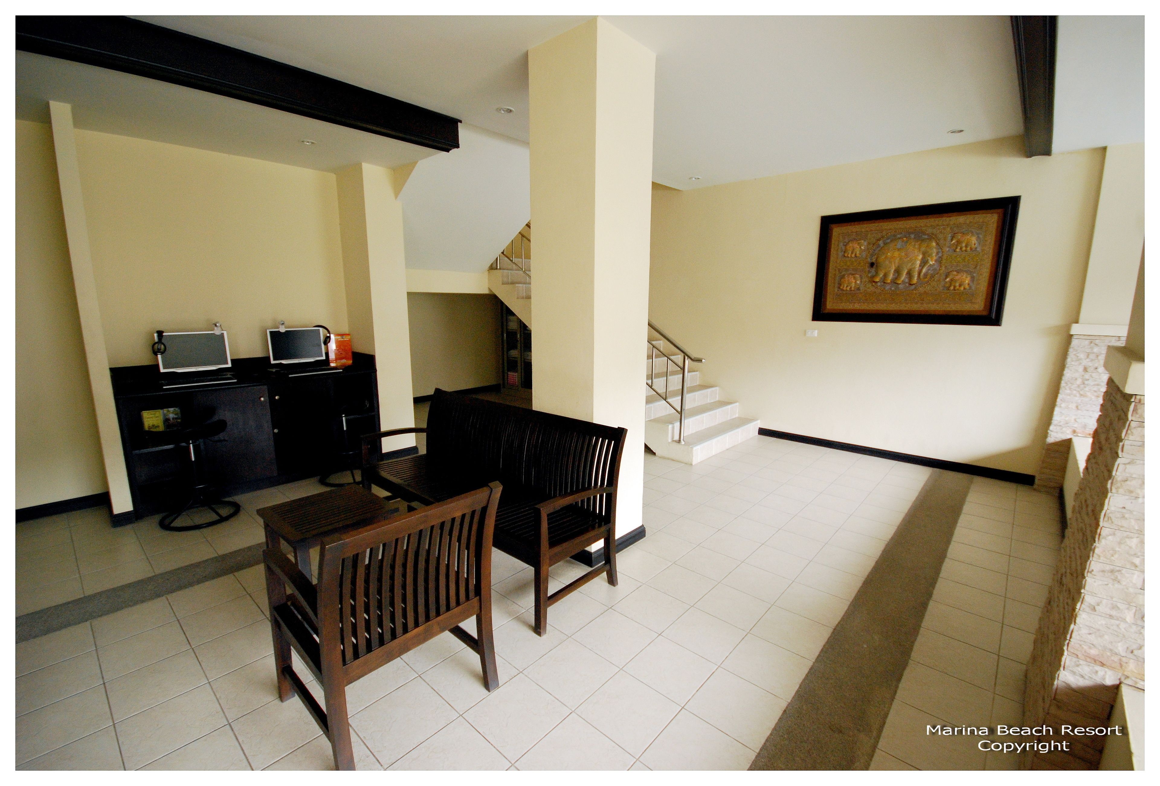 A dining area with a table and chairs, a black sofa, and a staircase leading to an upper level.