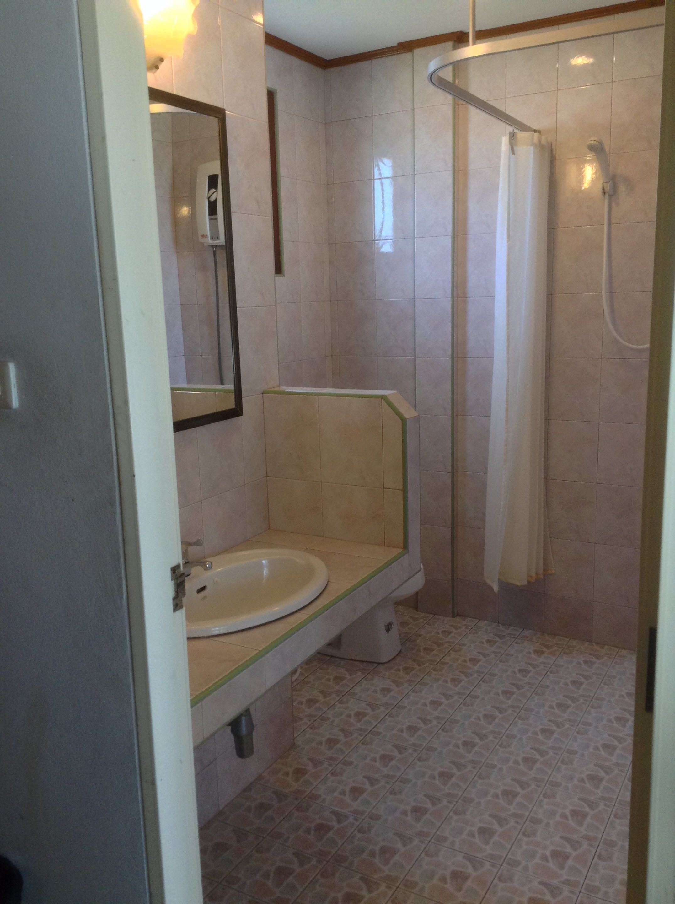 A bathroom with a toilet, sink, and shower.