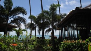 A tropical resort with palm trees, a beach view, and a traditional thatched-roof structure. - Lipa Bay Resort (Koh Samui)