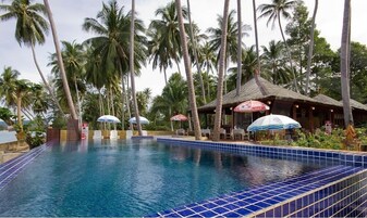 Una piscina al aire libre, sillones reclinables de piscina