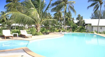 Una piscina al aire libre, sombrillas, tumbonas