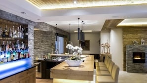 Un espace bar moderne avec un mur en pierre, un plafond en bois et une variété de bouteilles d’alcool.