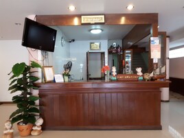 Un mostrador de recepción con un televisor, diplomas enmarcados y objetos decorativos.