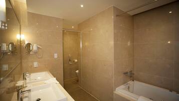 Un baño moderno con dos lavamanos, ducha y bañera.