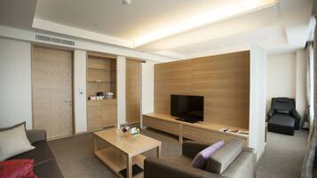 A modern living room with a sofa, a coffee table, a TV, and a wooden cabinet.