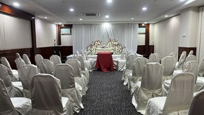 A conference room with rows of chairs, a stage with a floral arrangement, and a red table. - Hotel Seri Malaysia Genting Highlands (Genting Highlands)