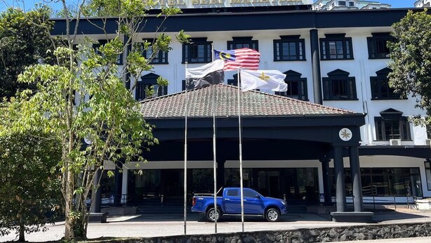 A building with a sign reading 'TEL SERI MALAYSIA' and a blue pickup truck parked in front. - Hotel Seri Malaysia Genting Highlands (Genting Highlands)