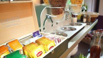 A coffee station with various tea and coffee options, including Lipton and Nestea, and a coffee machine.