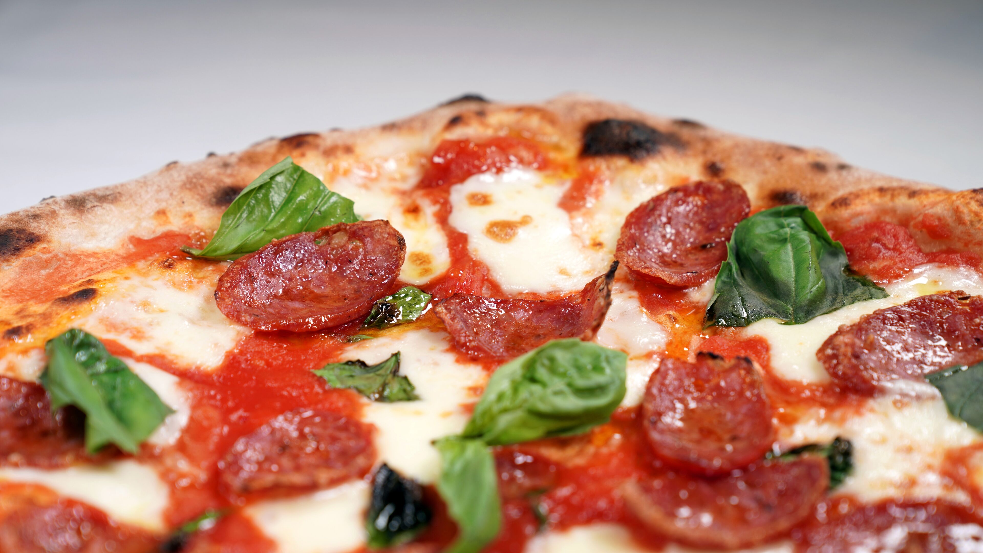A pizza with pepperoni and basil.