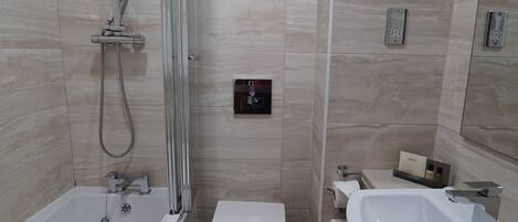 Een moderne badkamer met een bad, toilet en wastafel.