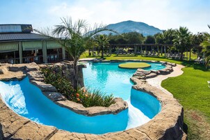 Una piscina al aire libre, sombrillas, tumbonas