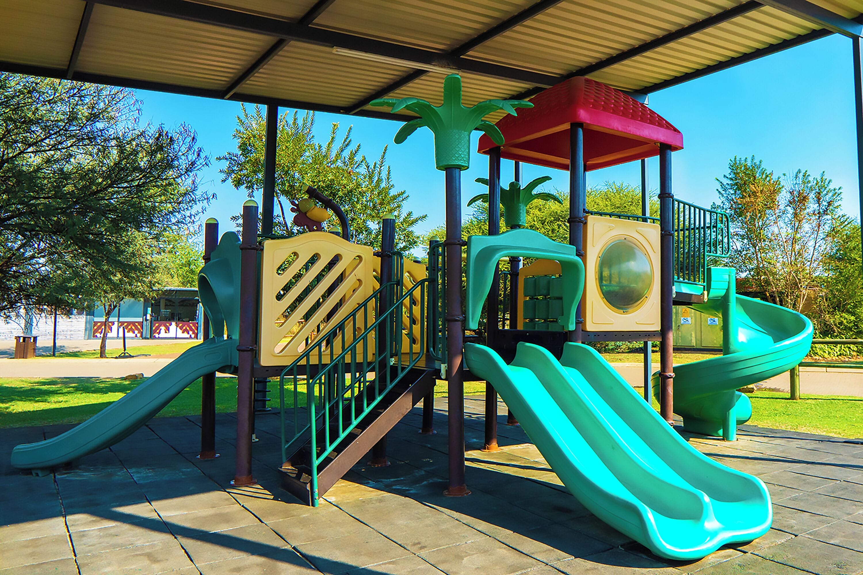 Un'area giochi con scivoli, strutture per arrampicata e una zona giochi al coperto.