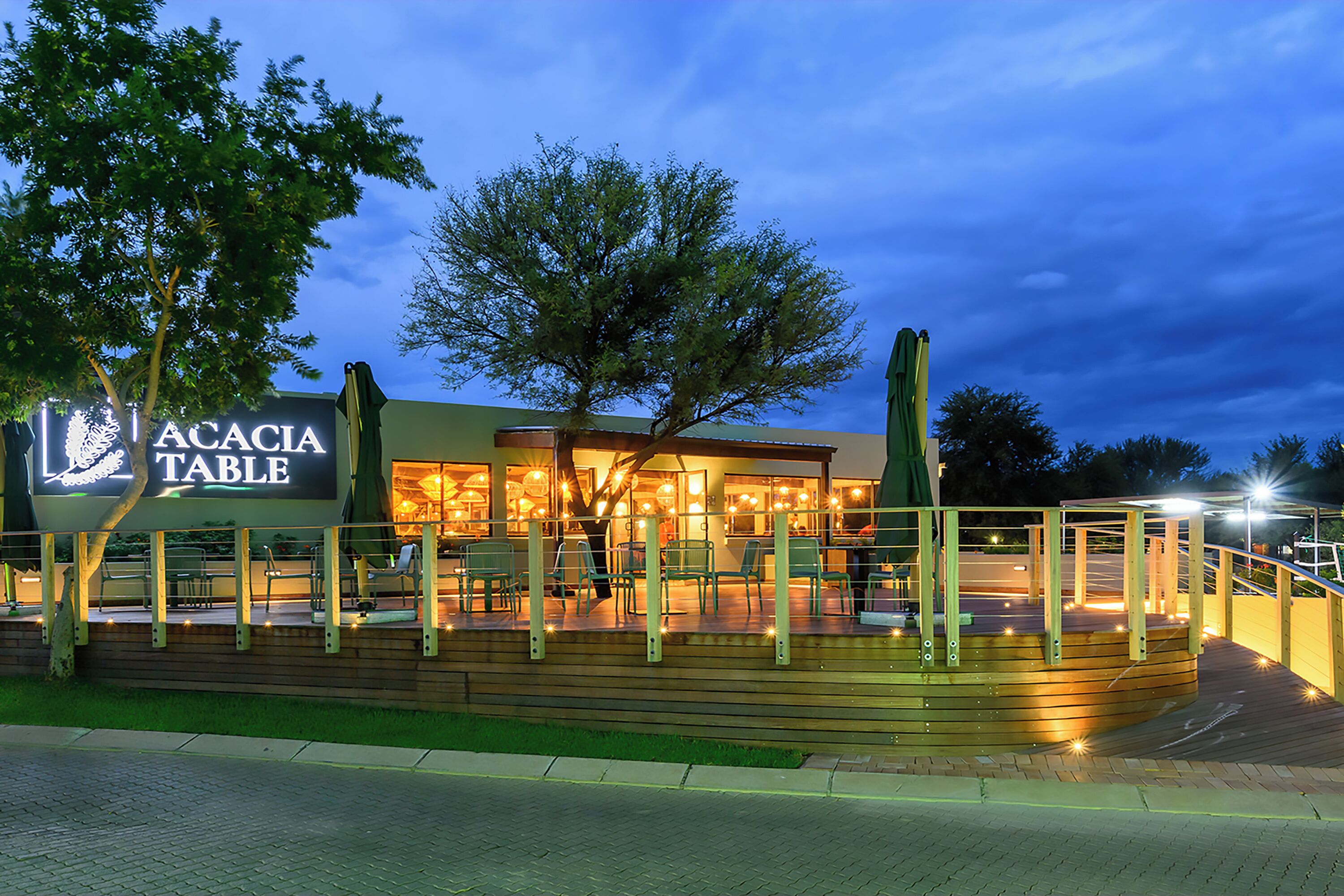 A restaurant named 'Acacia Table' with outdoor seating and a wooden deck.