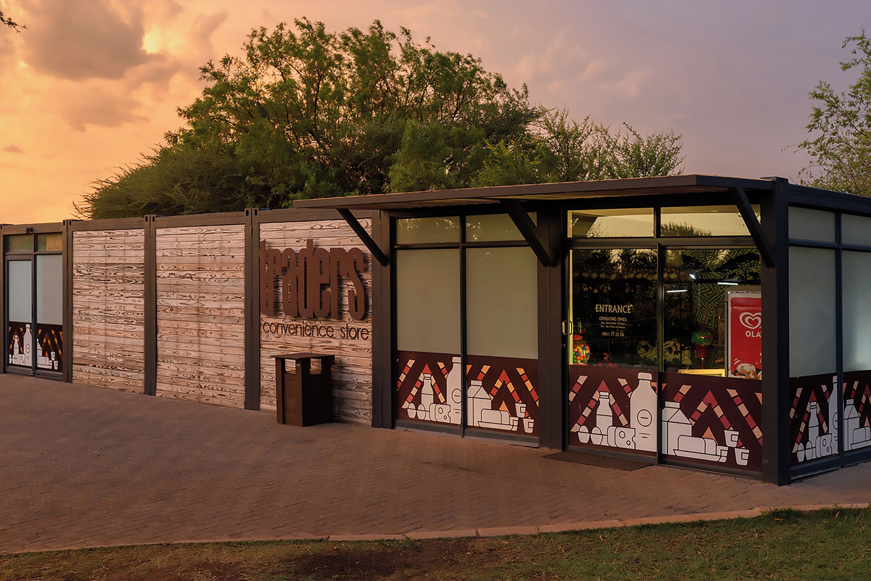 A modern building with a glass entrance, a wooden facade, and a sign that reads 'Experience Store.'