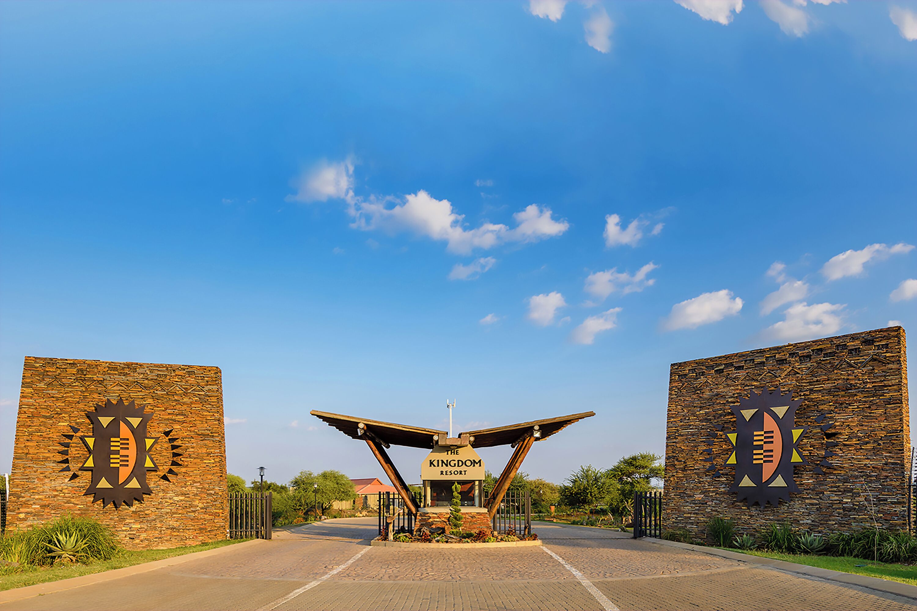 A brick entrance with a sign reading 'The Kingdom Resort' and a distinctive geometric logo.