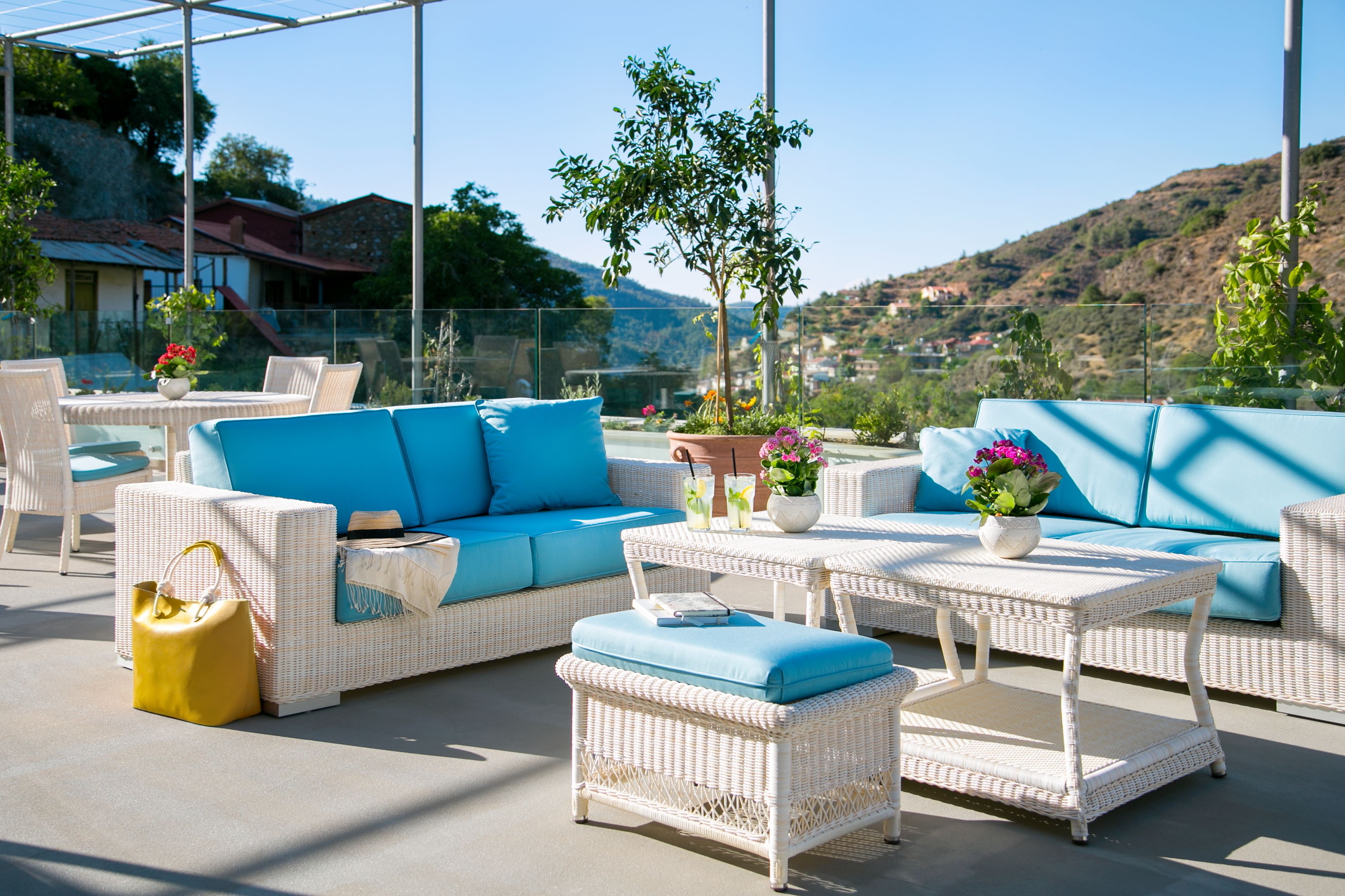 An outdoor seating area with wicker furniture and potted plants.