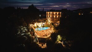 A large building with a swimming pool surrounded by outdoor seating and lighting. - Villa Clodia (Manziana)