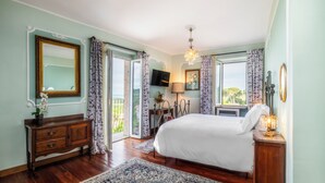 A bedroom with a large bed, wooden dresser, and a TV on a stand. - Villa Clodia (Manziana)
