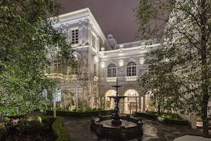 A historic building with a fountain in the courtyard, surrounded by well-maintained hedges and trees. - Casa Gangotena (Quito)