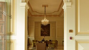 A grand lobby with a chandelier, ornate columns, and a seating area. - Casa Gangotena (Quito)