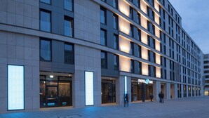 Een modern hotelgebouw met een strakke, rechthoekige gevel en gelijkmatig verdeelde ramen.