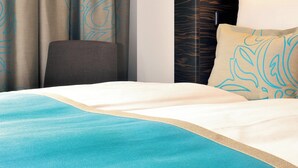 Een hotelkamer met een bed, een stoel en gordijnen.