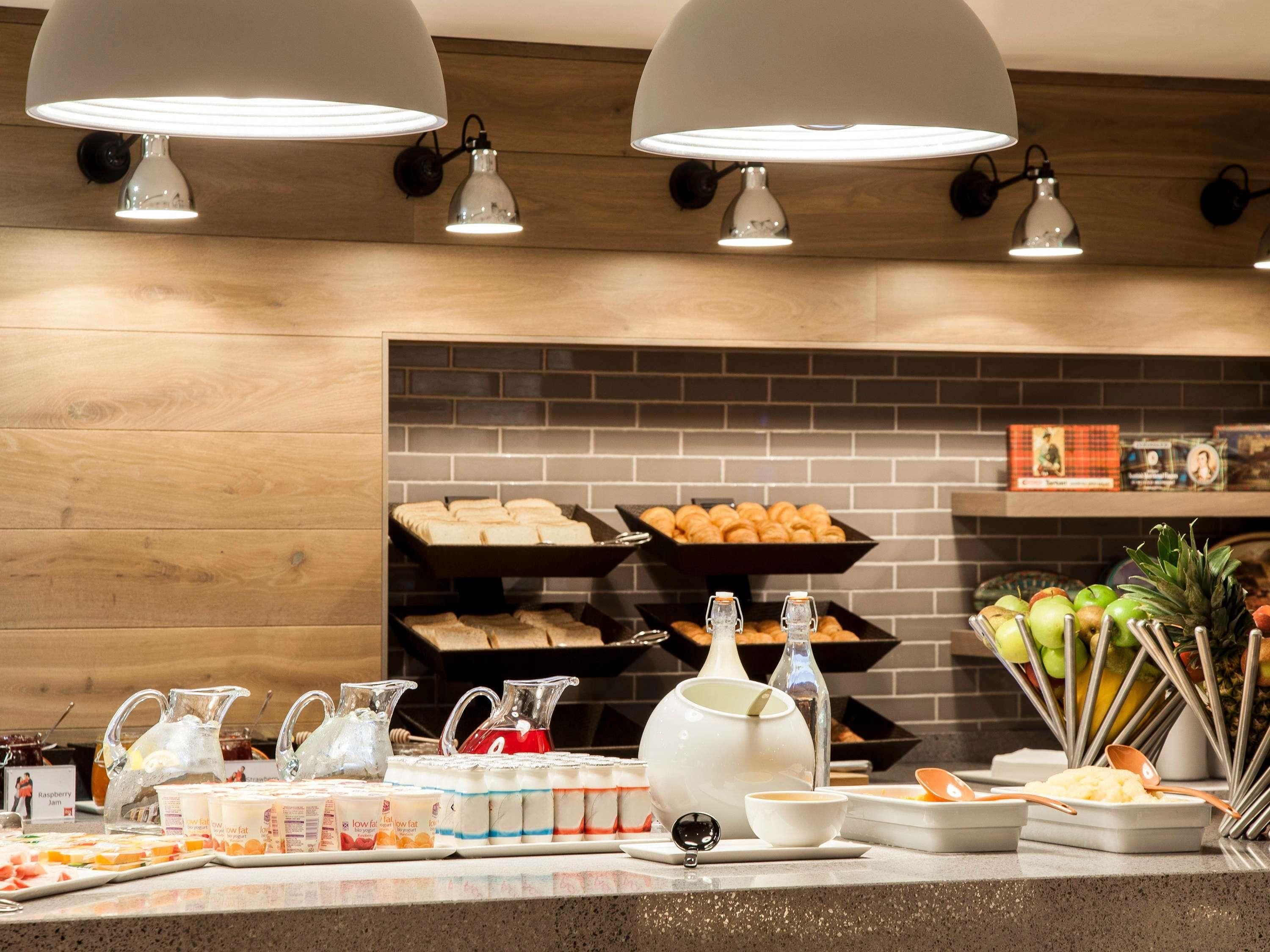 Una mesa de buffet con pan, bollería y fruta.