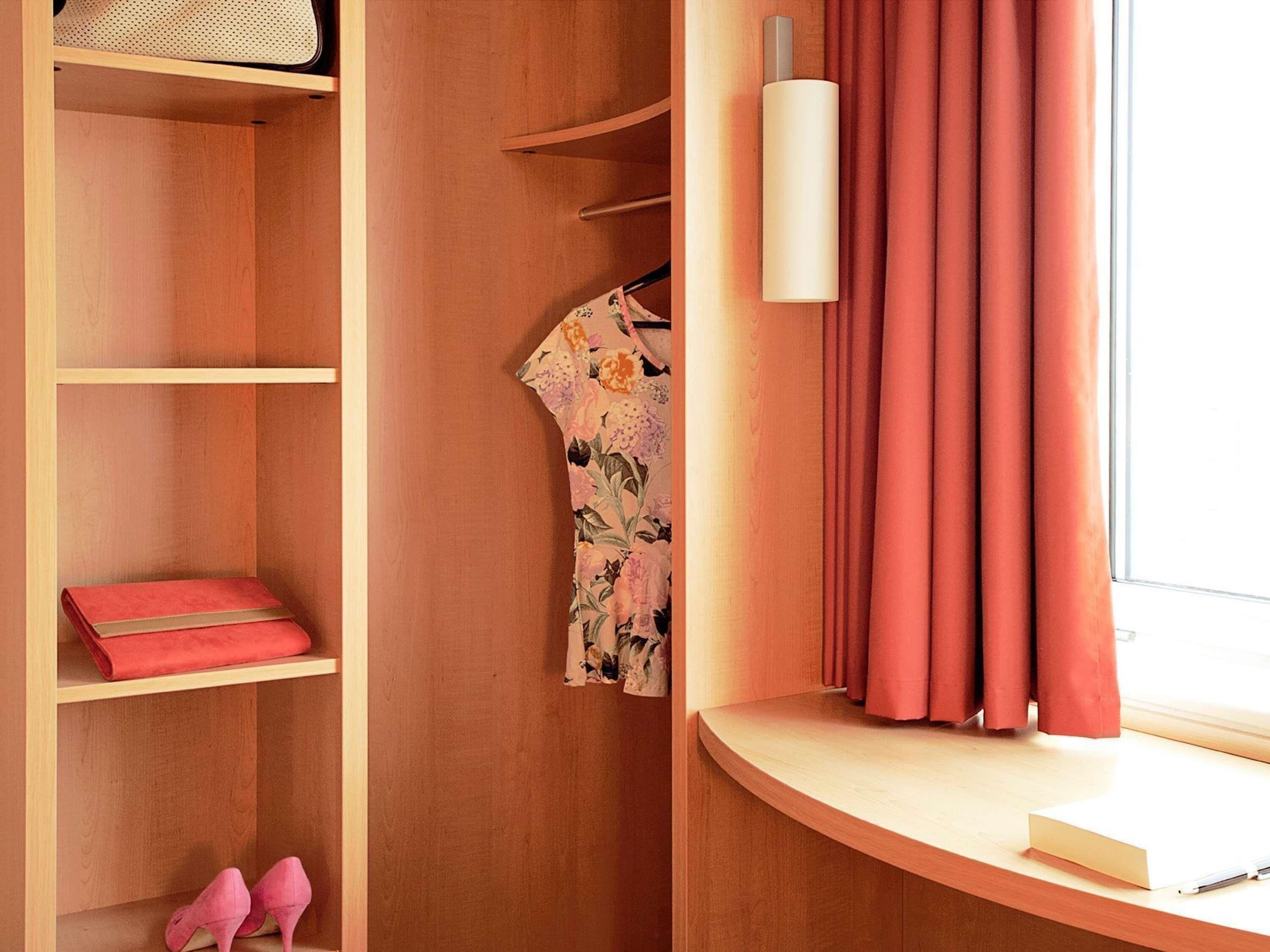 Een houten kast met planken, een kledingstuk en een paar schoenen.
